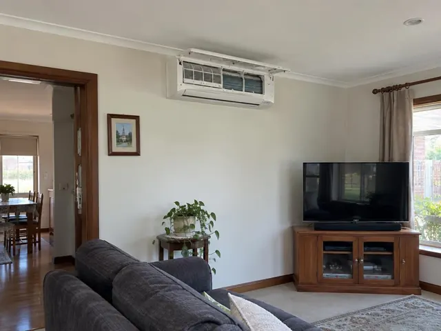 Open split system head with clean filters on a lounge room wall, above a TV and sofa in Morphett Vale